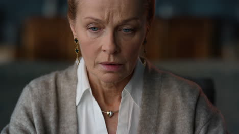 Serious-old-woman-working-computer-in-luxury-cabinet