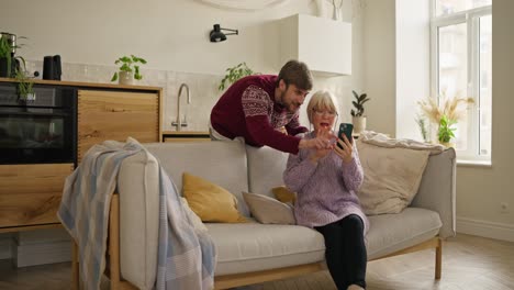 grandchild helping grandparent with smartphone