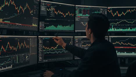 a focused trader analyzing market trends through multiple monitors displaying financial data and graphs in a high-tech trading environment