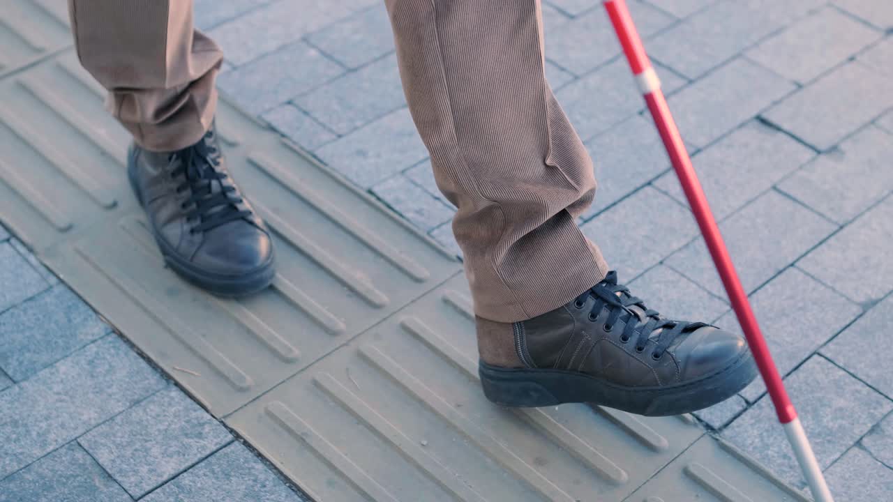 persona con un bastón para caminar usando pavimento táctil