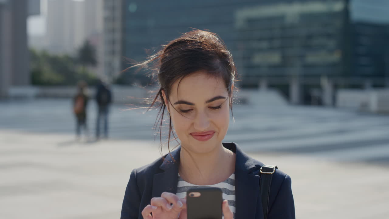 ritratto di una giovane donna d'affari di successo che utilizza uno smartphone, una donna professionista che invia messaggi di testo, si gode la comunicazione via telefono cellulare in città al rallentatore