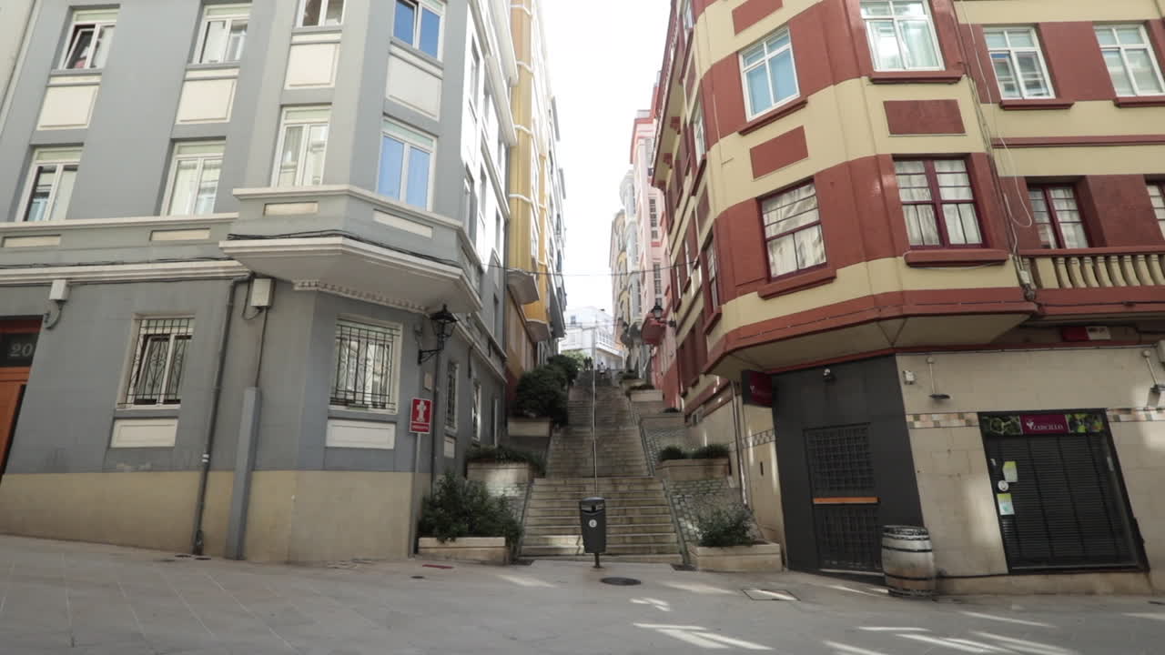 Narrow street with colorful old buildings and a steep staircase leading uphill