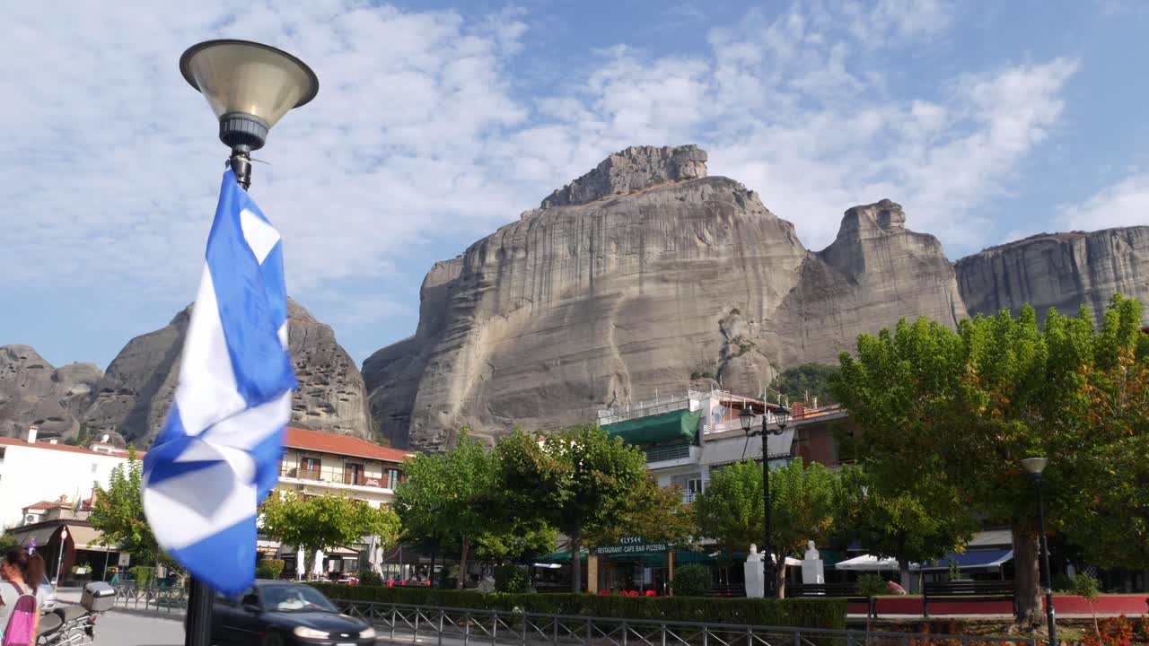 Greek flag and Meteora mountians range in the background