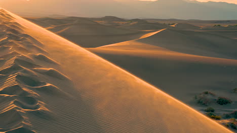 zandduinen die door de wind op de top van de berg in de woestijn waaien