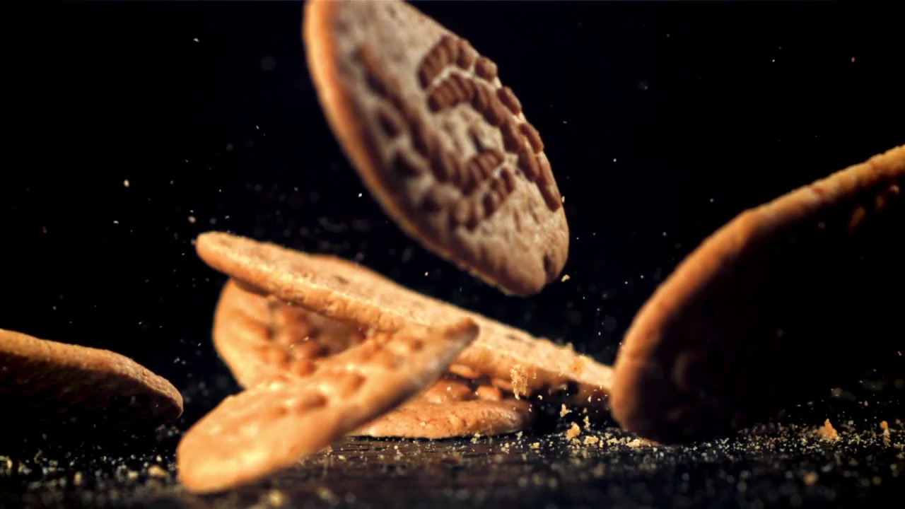 Delicious Cookies Falling and Breaking in Slow Motion on a Dark Background