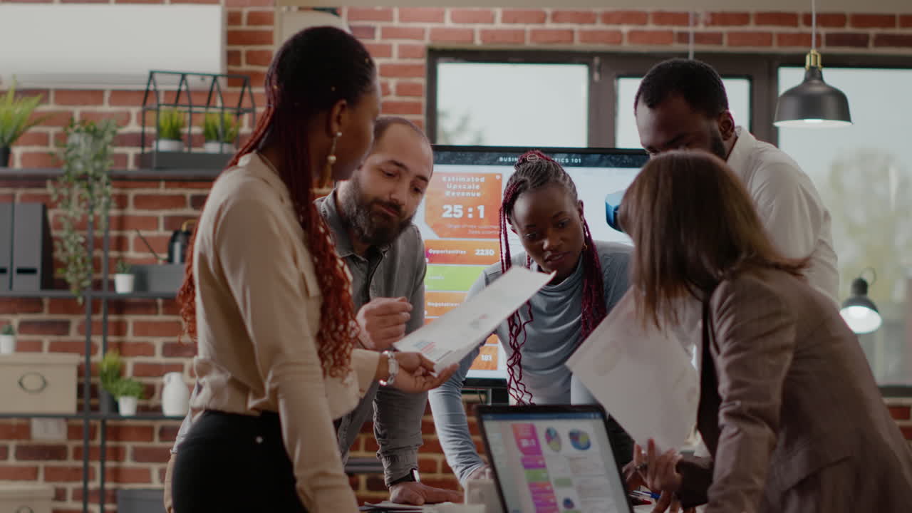 Team of colleagues analyzing charts on documents to plan project