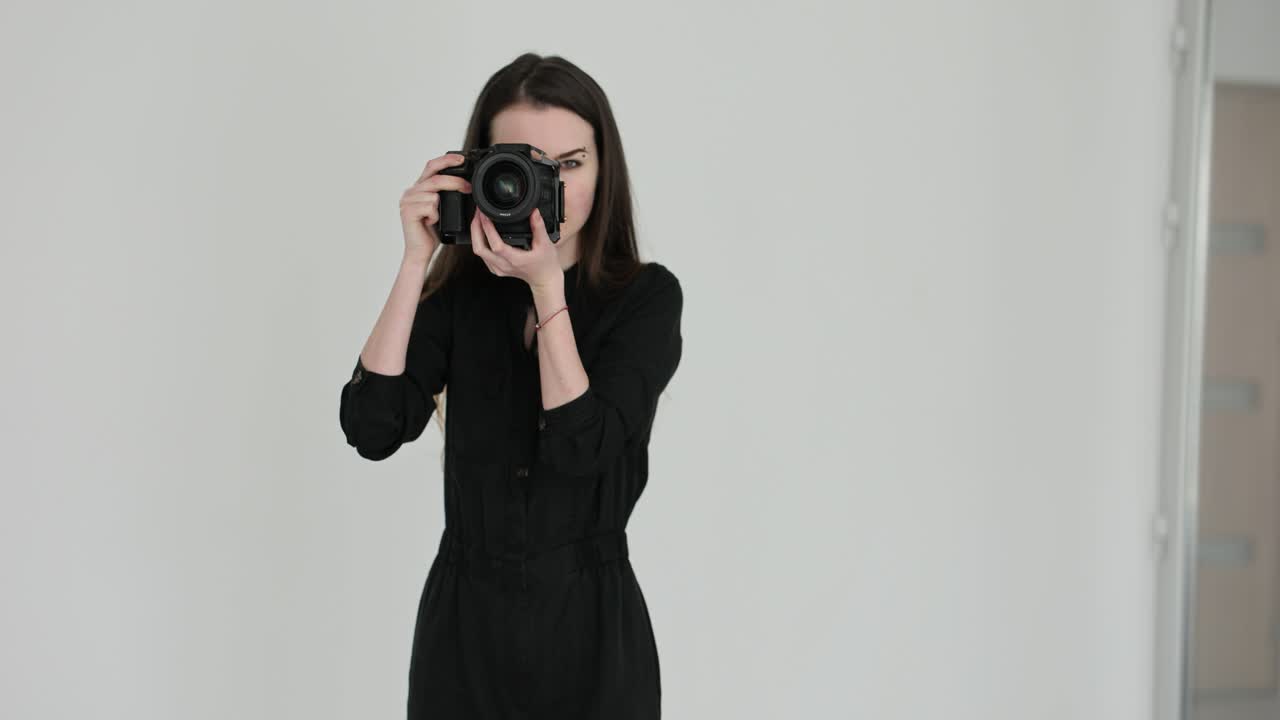 A woman taking photos with a professional camera in a studio