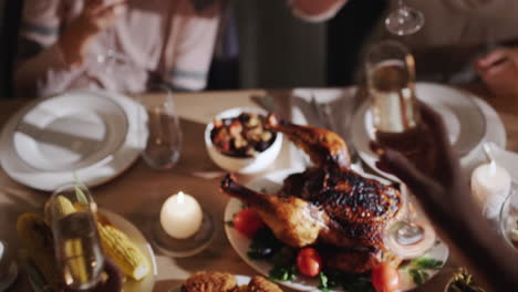 a group of people clink glasses of champagne over a festive table where roasted turkey is served. top view