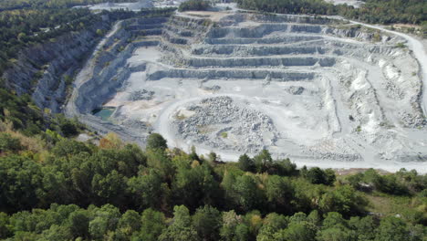 quarry surrounded by lush green forest, summer day