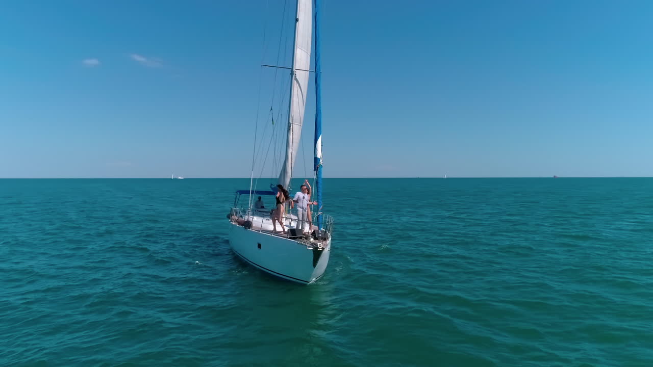 Big yacht riding on the sea. Young group of people have a rest on a yacht.