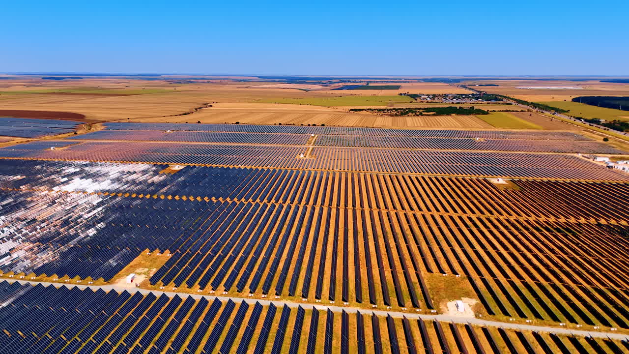 Vast solar field under clear sky. Sunlight shines on a vast field filled with solar panels, showcasing renewable energy potential in rural landscape