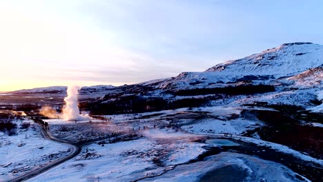 panoramic view of mountains under the red sunset in geysir, iceland. there is geysers in the wonderful famous place for travelers. a lot of smoke is getting out of the geyser.