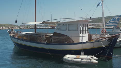 lovely wooden carvel built sail boat moored at quite greek village harbor close up