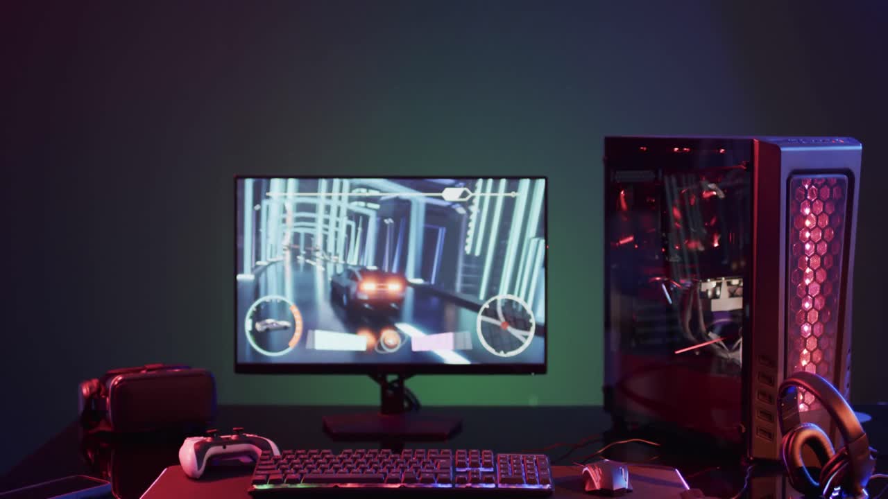 Video of computer and gaming equipment on desk with copy space on neon background