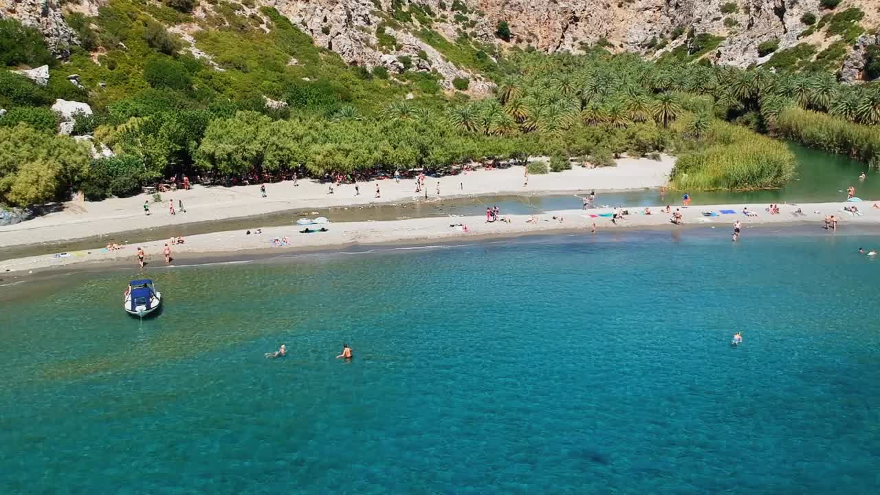 A heavenly beach and lagoon with taxi boats and yachts visiting from nearby villages, Preveli beach and palm forest, Crete