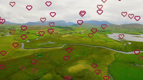 hearts animation over lush green landscape with mountains in background