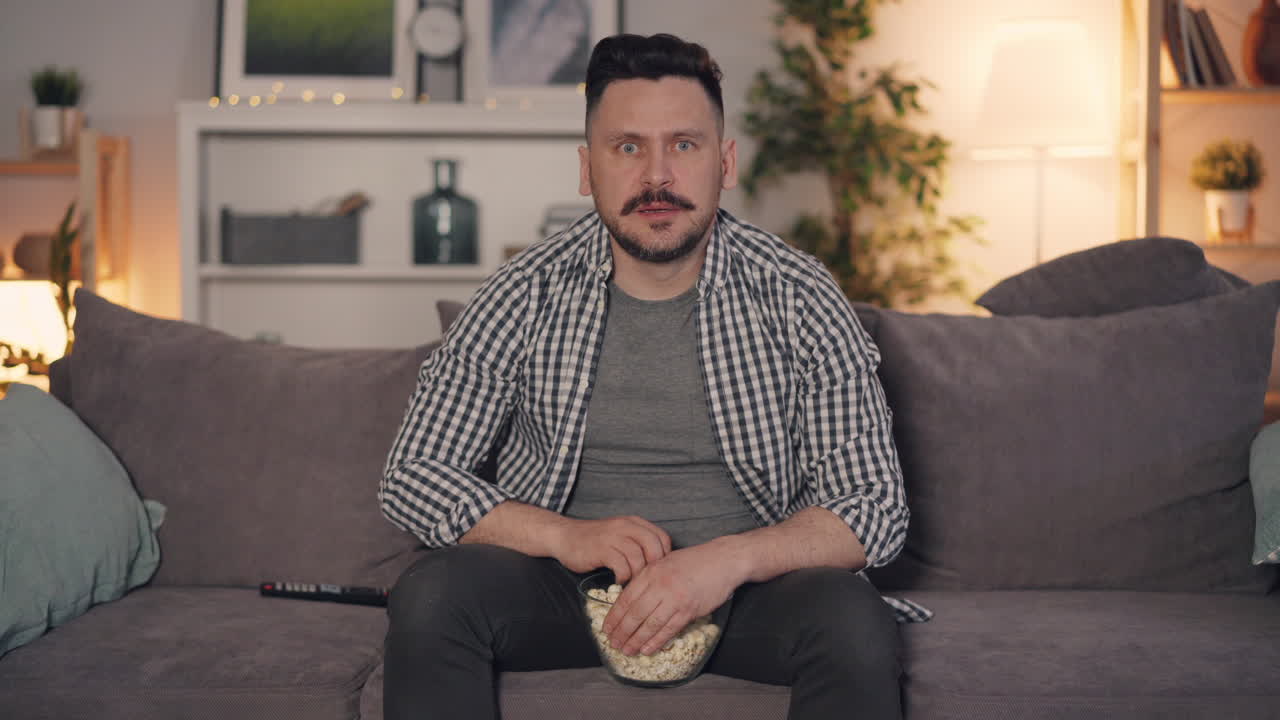 Man watching a movie and eating popcorn