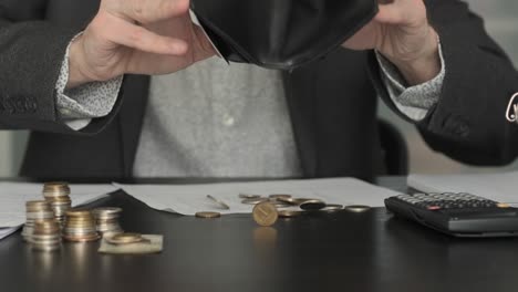 businessman counting coins on the table