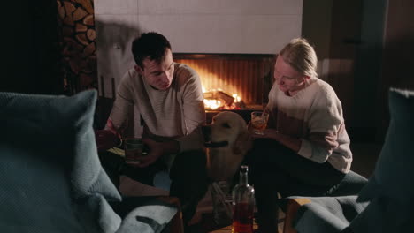 couple relaxing by the fireplace with a dog