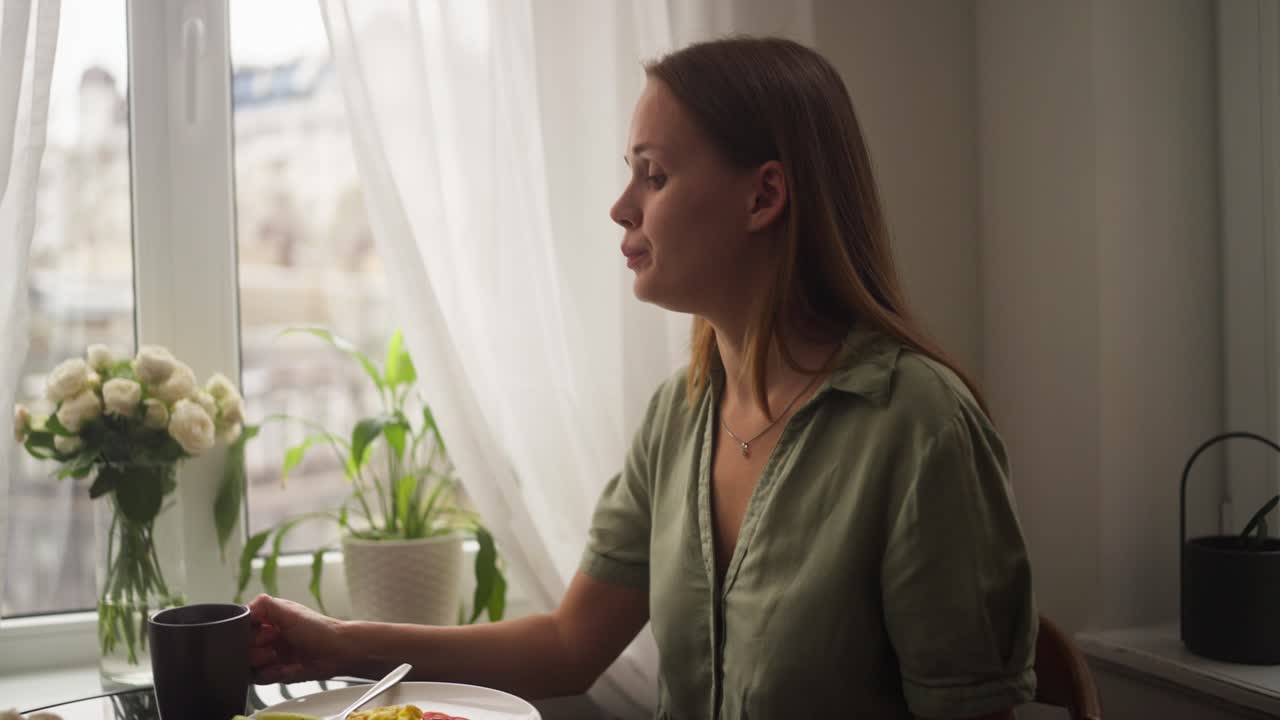 mujer desayunando junto a la ventana