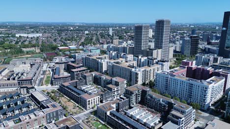 Aerial-view-flying-across-Stratford-London-downtown-district-skyscraper-cityscape-blocks-under-blue-sky