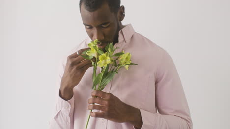 young man touching and smelling flowers