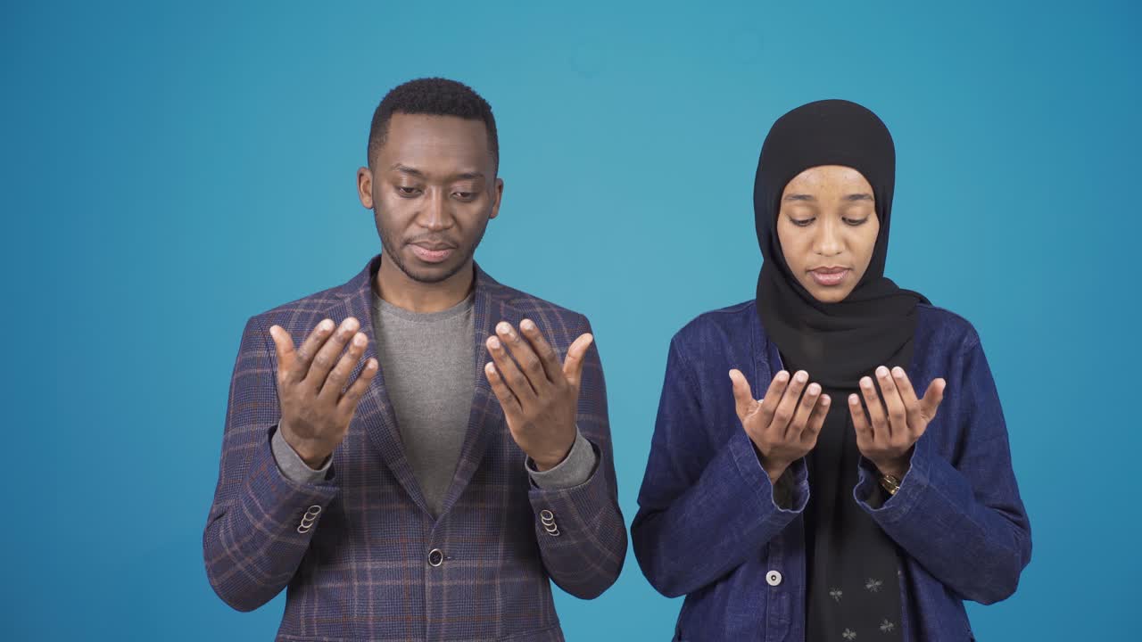 Pria muslim Afrika dan wanita berhijab sedang berdoa.