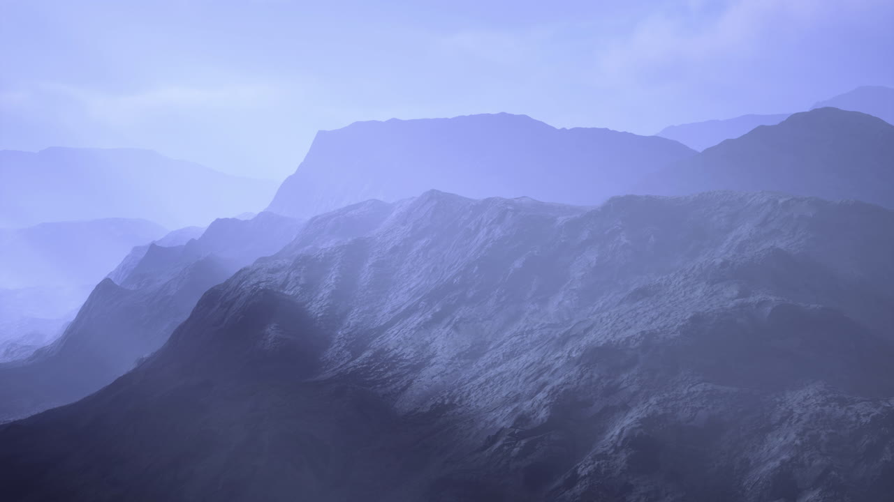 Misty mountain landscape enveloped in soft blue hues during early morning light