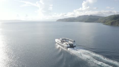 A-Passenger-Fastcat-Ferry-Boat-Cruising-And-Leaving-Wake-On-The-Calm-Blue-Ocean-Against-Warm-Sunlight-In-Liloan,-Southern-Leyte,-Philippines---Aerial-Drone-Shot