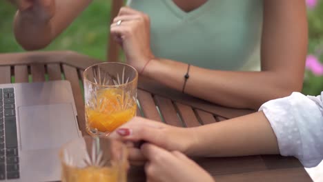 vista de ángulo alto de mujeres jóvenes irreconocibles hablando en un café al aire libre, gestos, de cerca de las manos