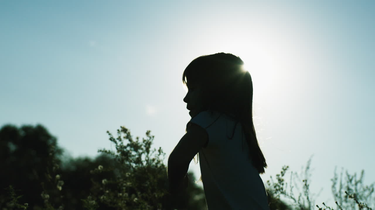 해가 지는 동안 에서 달리는 소녀의 실루