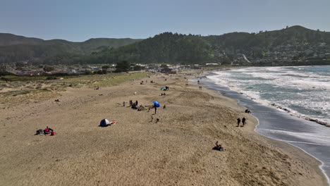 Pacifica-California-Aerial-v3-low-level-flyover-state-beach-at-linda-mar-capturing-beachgoers-on-the-sandy-shore-with-san-pedro-mountain-valley-view-on-a-sunny-day---Shot-with-Mavic-3-Cine---May-2022