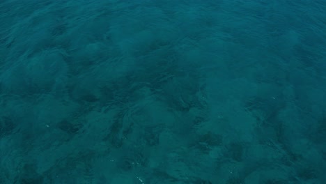 Cala-Aguila-beach-Mallorca-clear-blue-water-flying-towards-the-beach-with-crashing-waves-and-sunny-weather