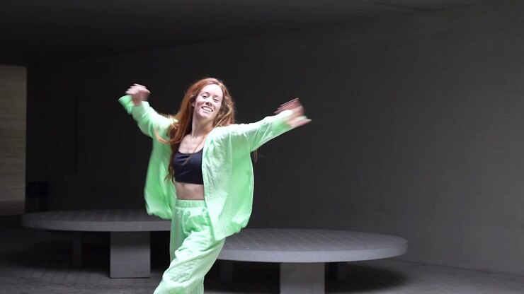 A graceful woman displaying fluid dance moves in a contemporary simplistic environment