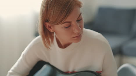 a red haired woman learning to play the electric guitar 1