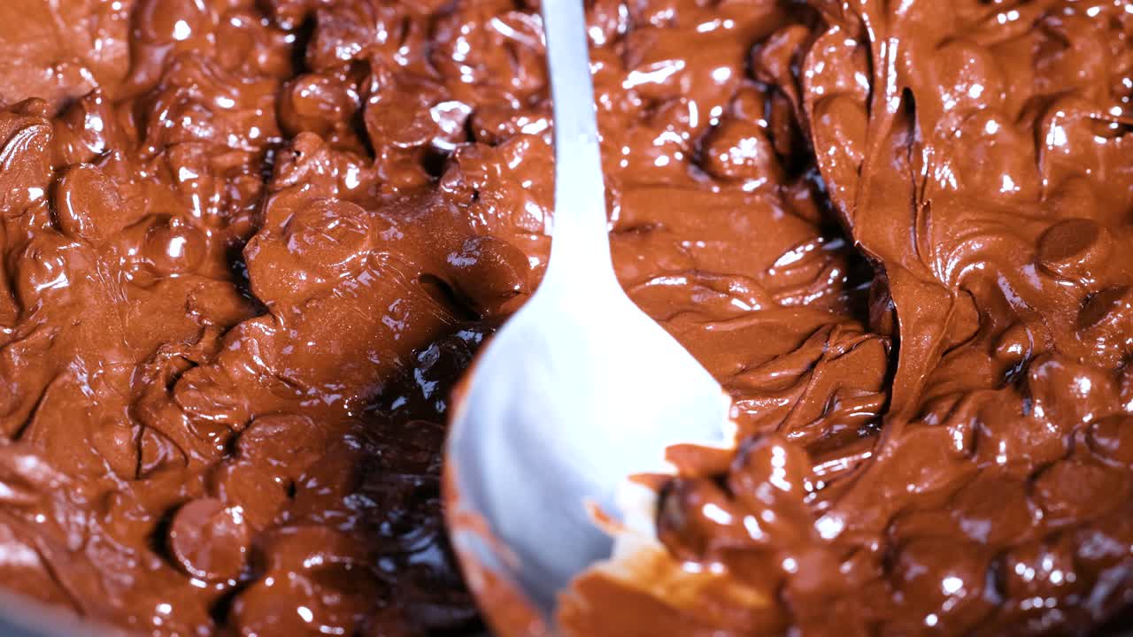 Spoon stirring melting chocolate chips smoothly