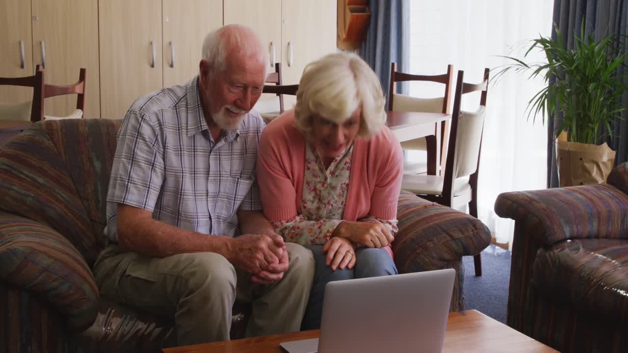 старшая пара в социальном дистанции с помощью ноутбука