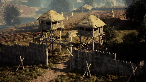 ancient village with wooden palisade and watchtowers