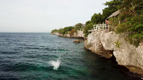 菲律賓潘格拉奧島 (panglao island) 的一個小男孩從卡利卡桑懸崖跳入深藍色熱帶水域