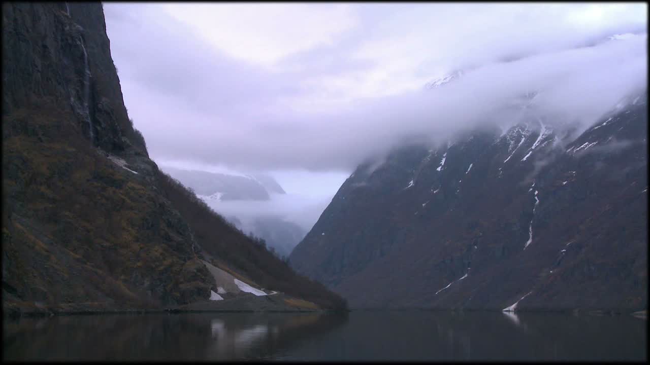 nubes y niebla cuelgan sobre un fiordo en noruega en timelapse 1