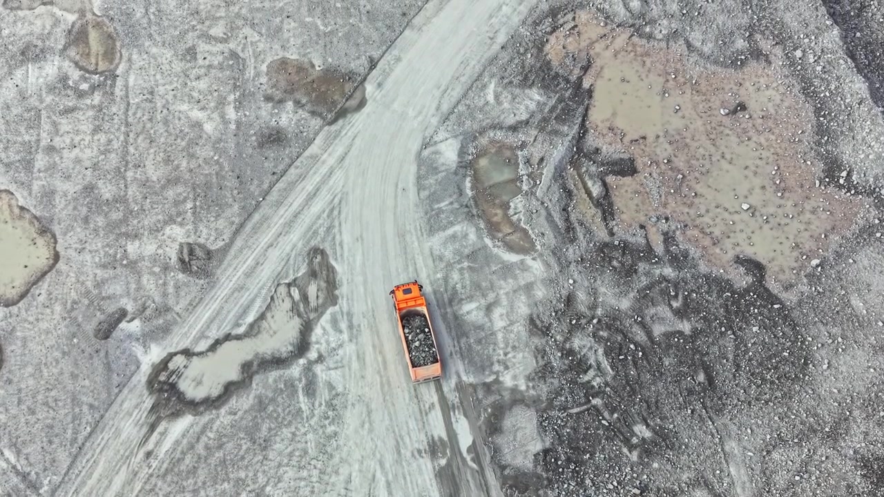 Granite quarry operations with construction vehicle on rocky landscape
