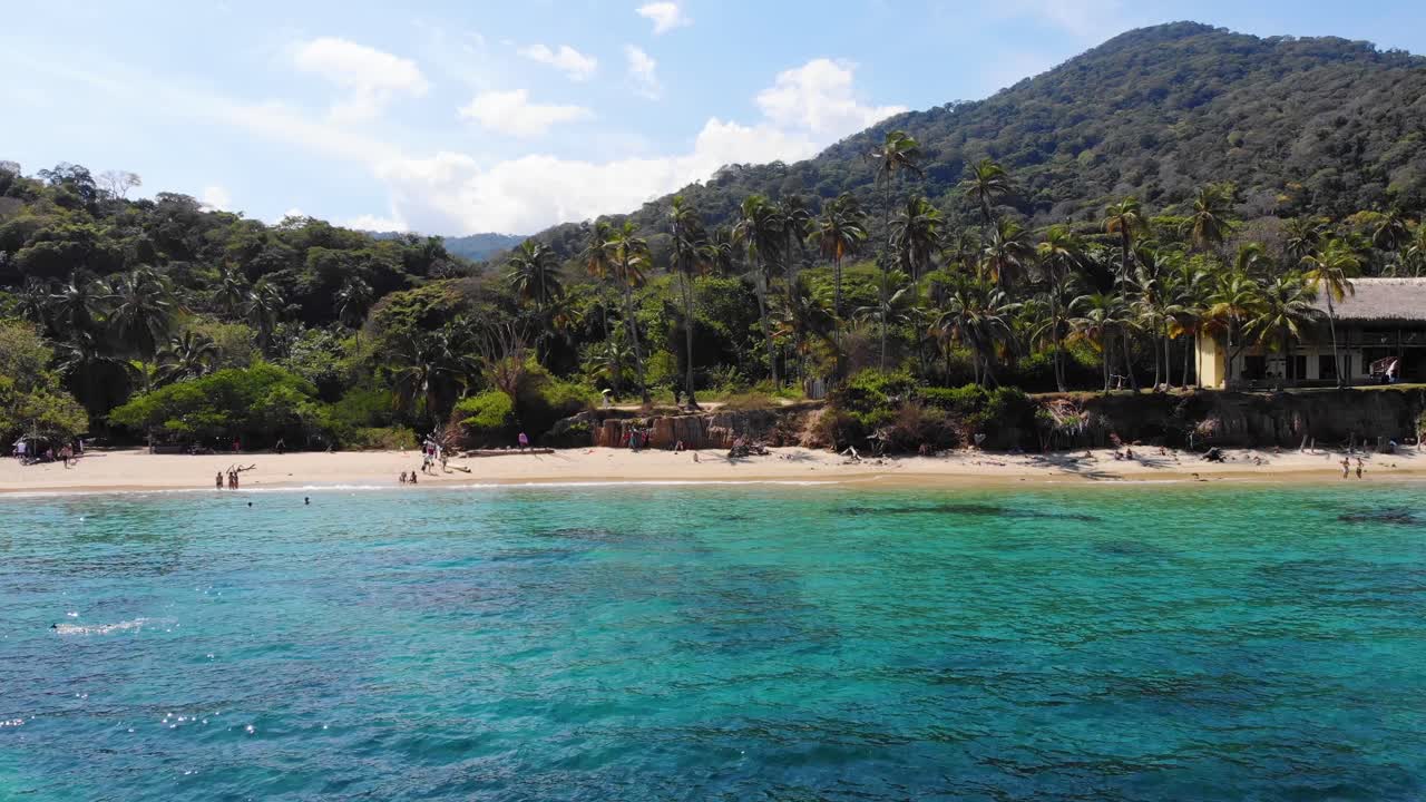 vista aérea desde una playa, sobre el mar turquesa, en el parque natural nacional de tairona, colombia - retiro, disparo de avión no tripulado