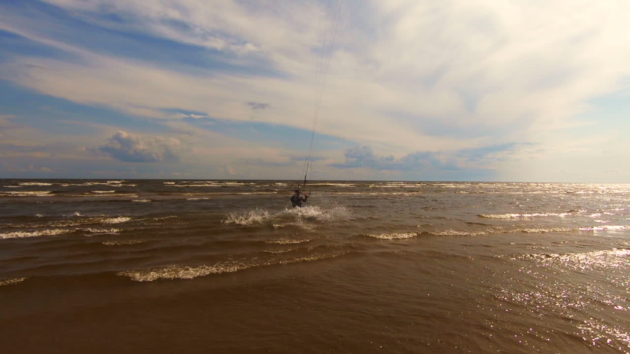 kitesurfista haciendo un flip mientras cabalga las olas