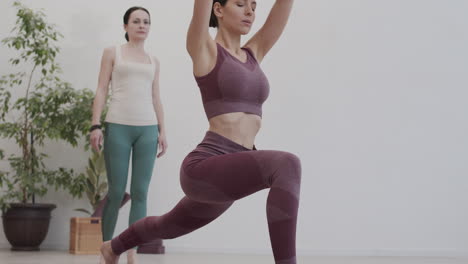 entrenadora observando a una deportista haciendo yoga
