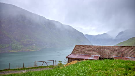 misty weather over countryside in norwegian fiord, flam village area