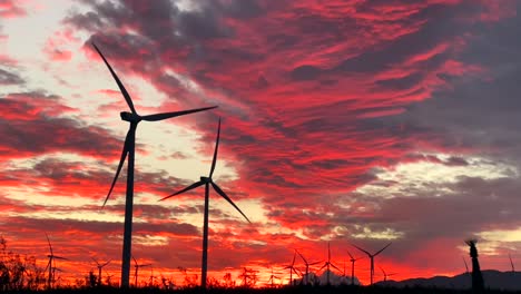 dramatic colorful sunset, wind turbines, clean renewable energy, red and orange sky
