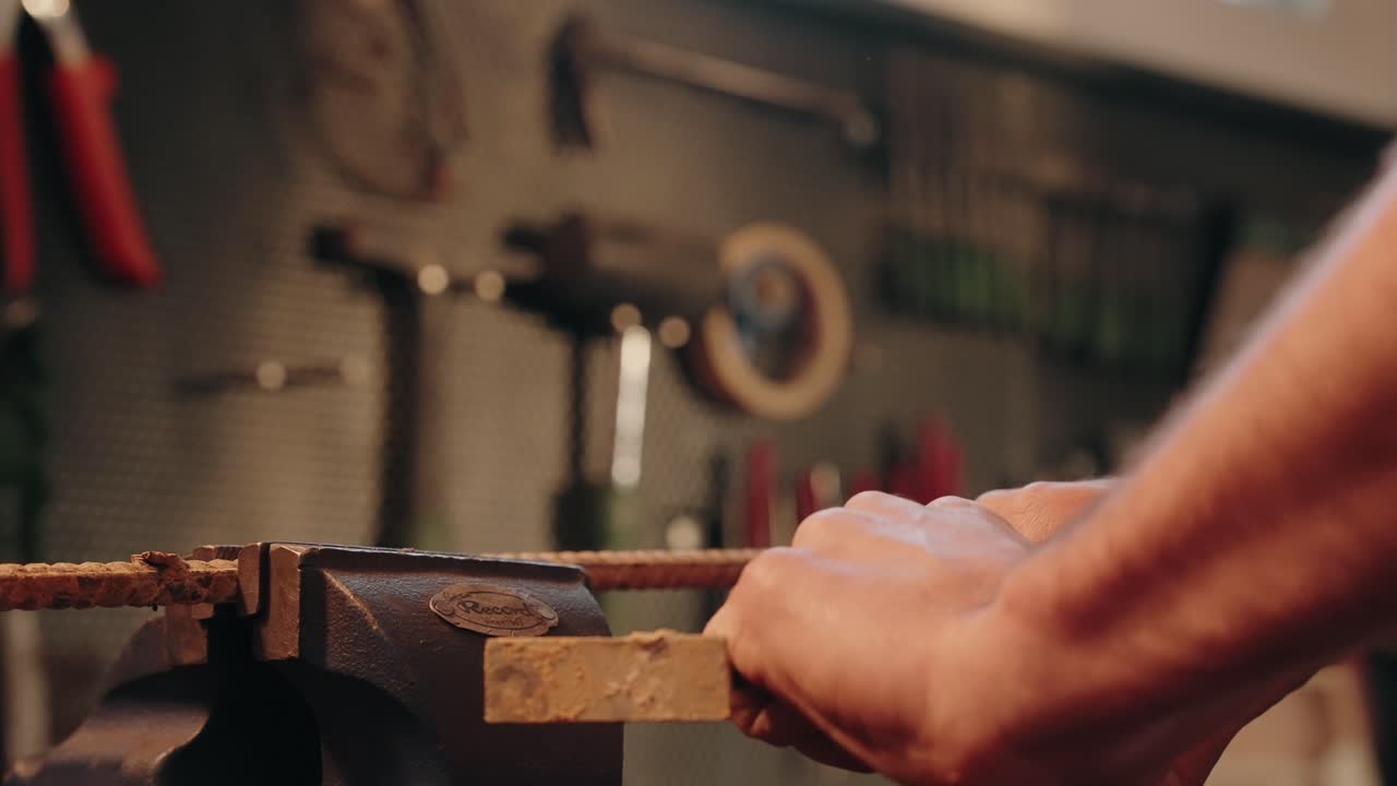 Grinding metal rod with angle grinder tool in workshop full of flying sparks