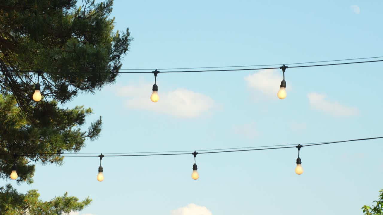 저녁에 접근하는 기둥에서 매달려 있는 거리 장식 전구 희미한 조명