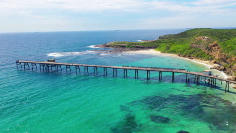 Aerial:-Catherine-Hill-Bay-pier-and-turquoise-seascape,-Australia-east-coast
