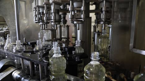 Plastic-bottles-rotate-on-an-automated-machine-as-they-are-filled-with-fresh-vinegar-at-a-factory-processing-plant